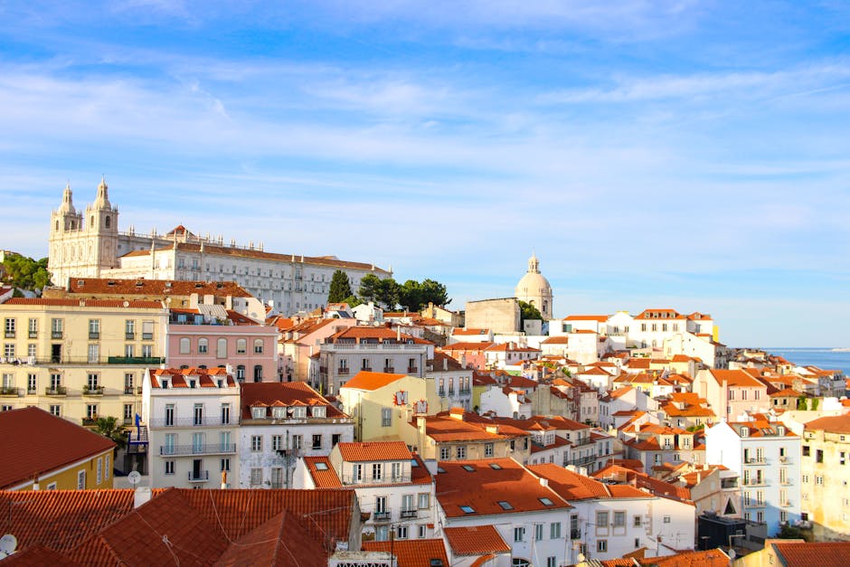 A scenic view over Lisbon's historic Alfama district showcasing traditional architecture under a clear sky.