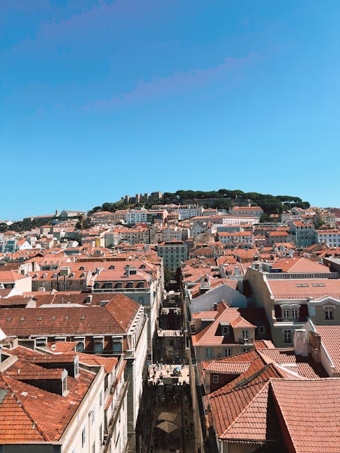 Scenic aerial view of Lisbon with historic architecture under a clear blue sky.
