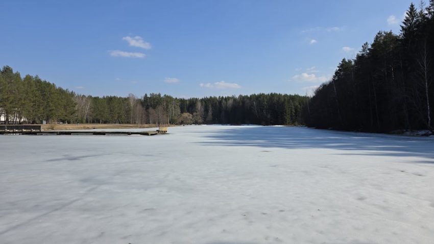 A frozen lake in early spring, where quiet cracks in the ice signal the slow, inevitable return of movement.