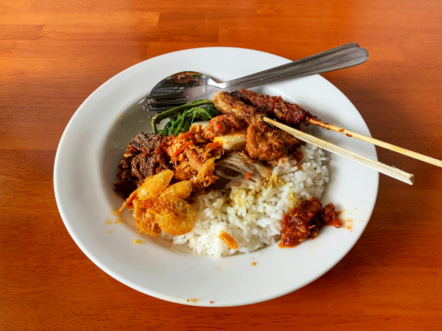 Delicious Nasi Campur with rice, meat, and vegetables served in Bali, Indonesia.