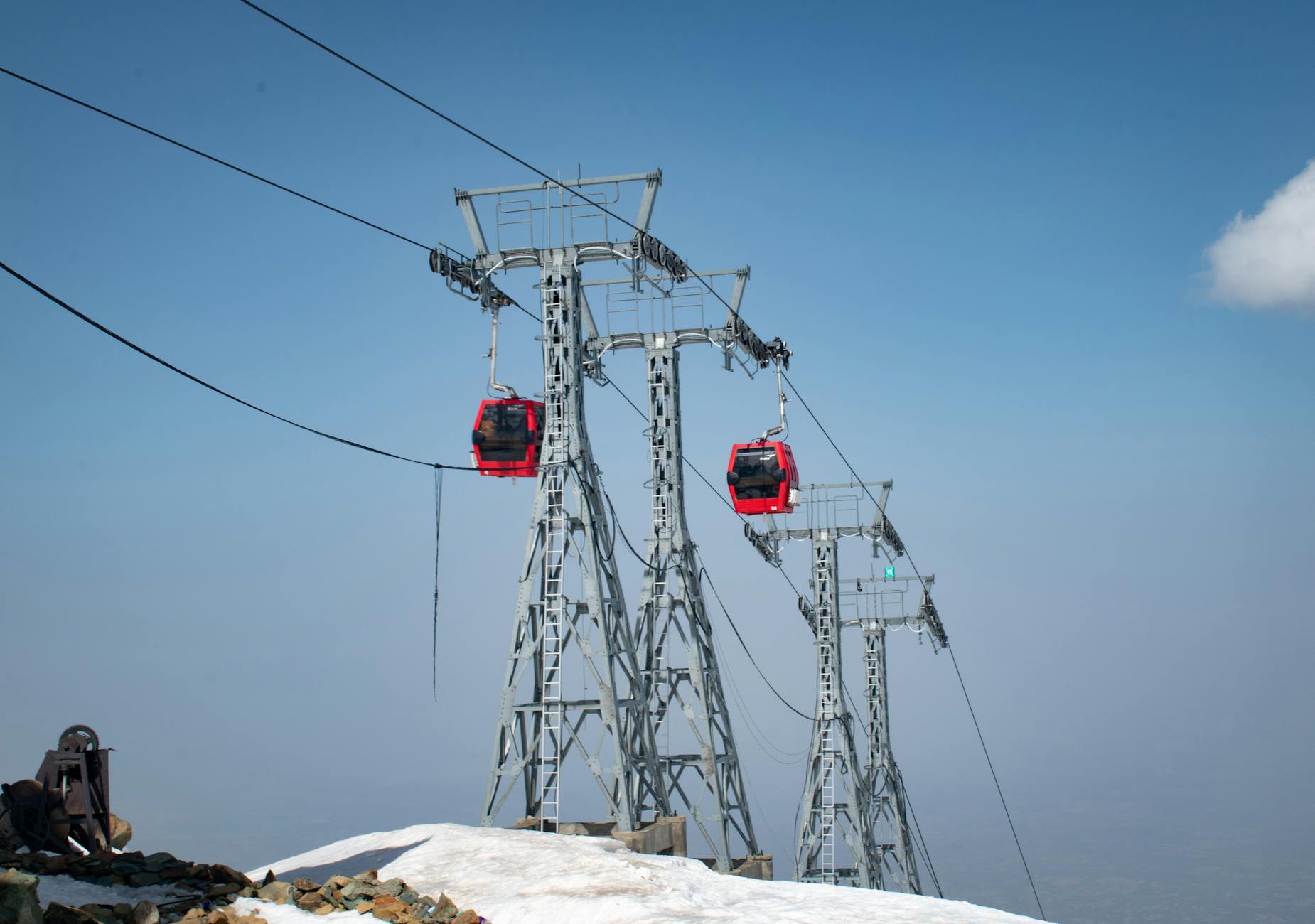 Scenic view of Gulmarg Gondola cable cars against a snowy landscape and clear sky.