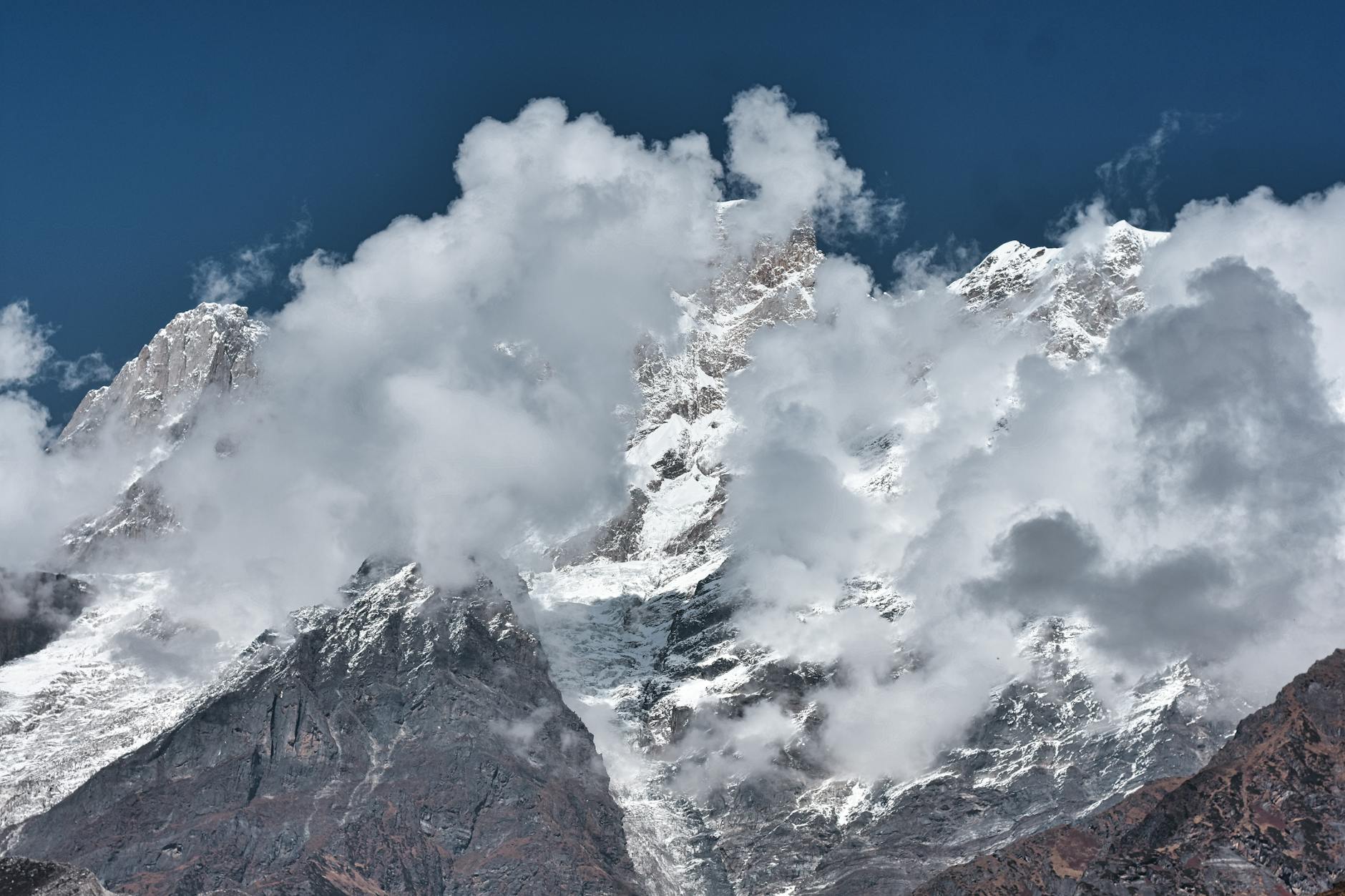 Stunning view of Kedarnath's snow-capped mountains enveloped by dramatic clouds.