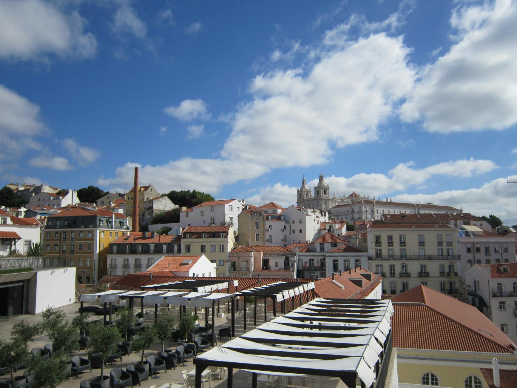 Beautiful cityscape of Lisbon showcasing historic architecture and iconic rooftops under a vibrant blue sky.