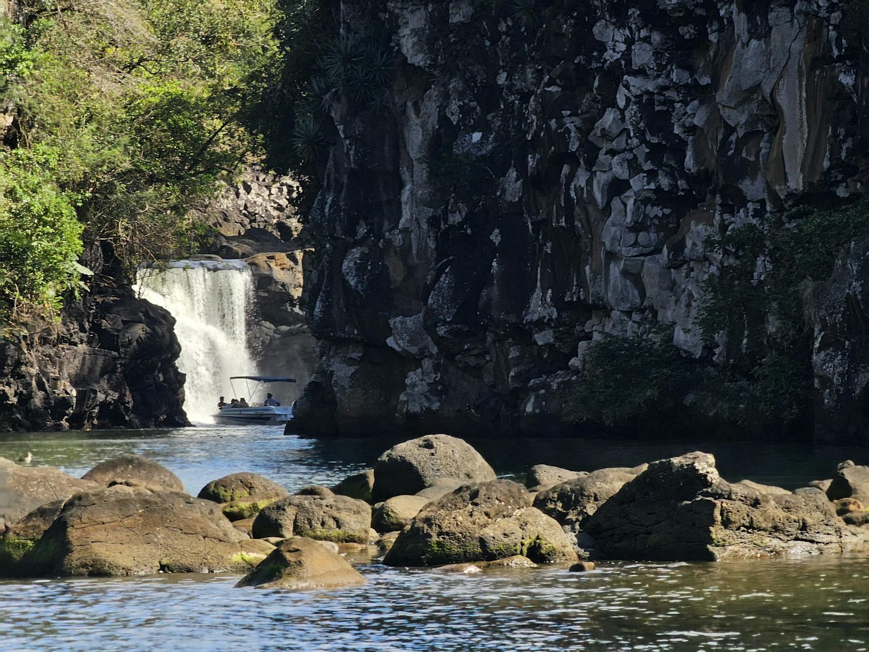 Explore the beautiful waterfall surrounded by rugged rocks and lush greenery in Mauritius.