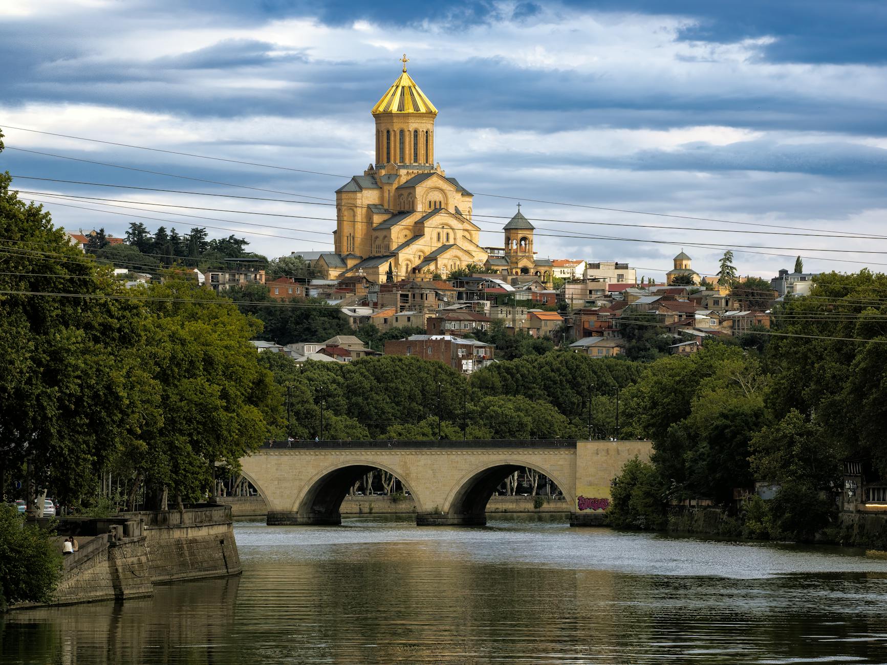 Scenic view of the Holy Trinity Cathedral and bridge over the Kura River in Tbilisi, Georgia.