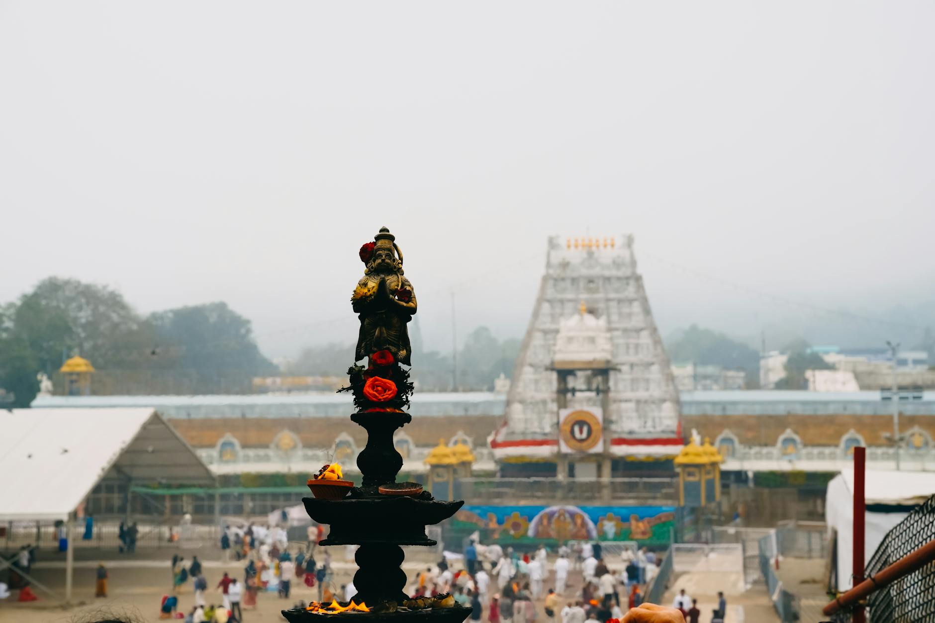 View of Tirupati Temple with a traditional oil lamp in the foreground, capturing the essence of Indian spirituality.
