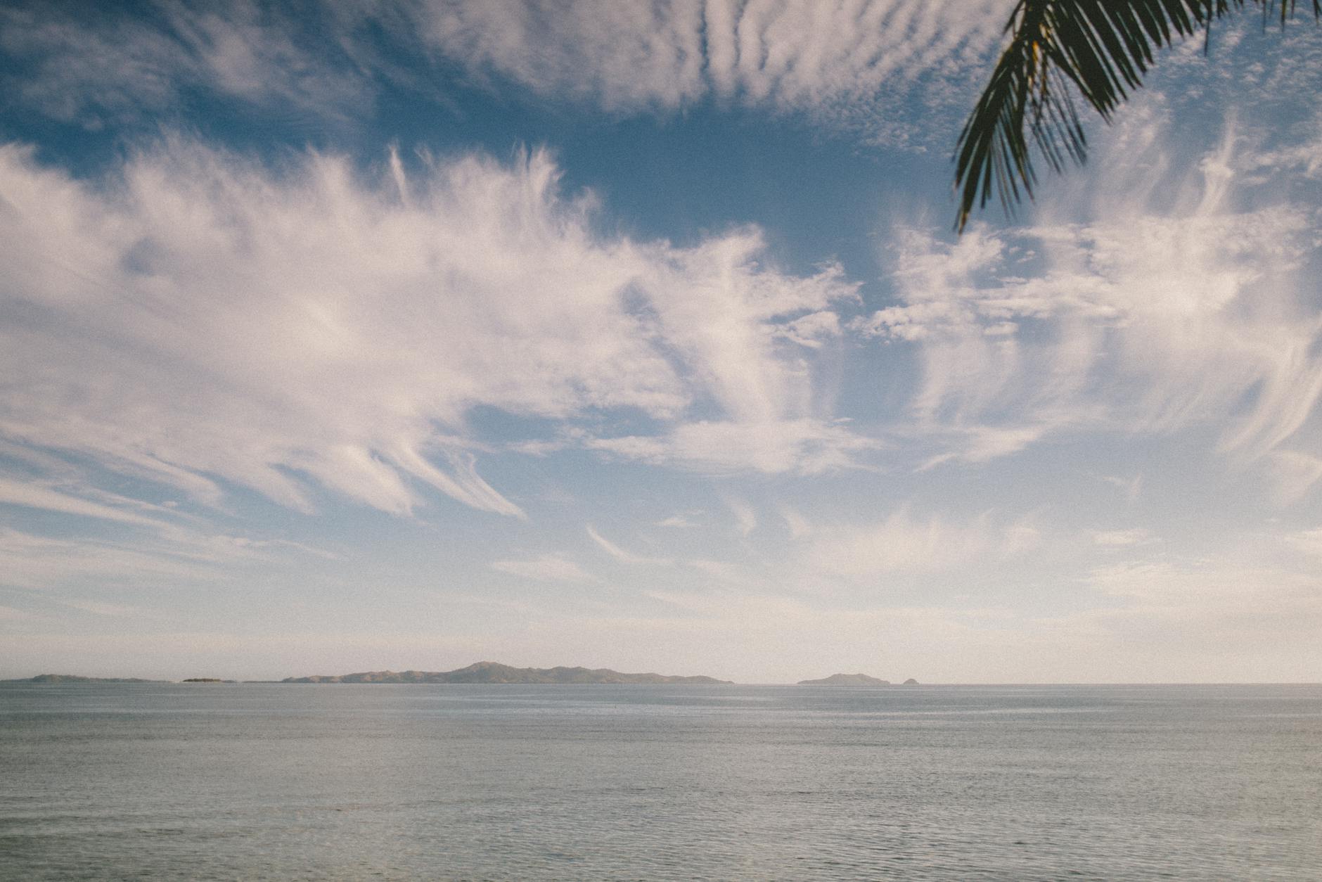 Tranquil ocean scene at Nadi, Fiji with striking clouds and gentle waves.