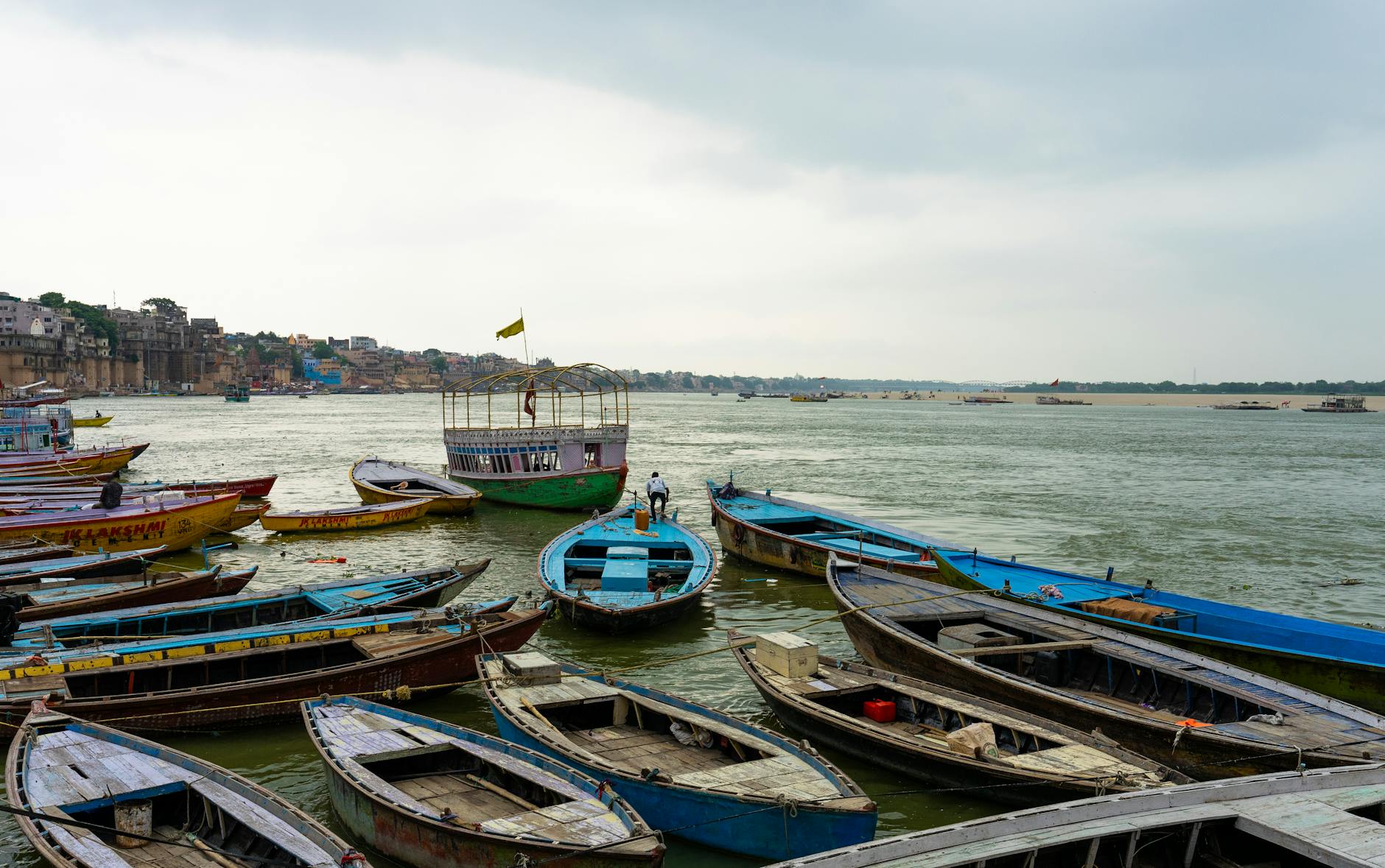 Wooden boats moored on the Ganges River in Varanasi, depicting a rustic urban waterfront scene.