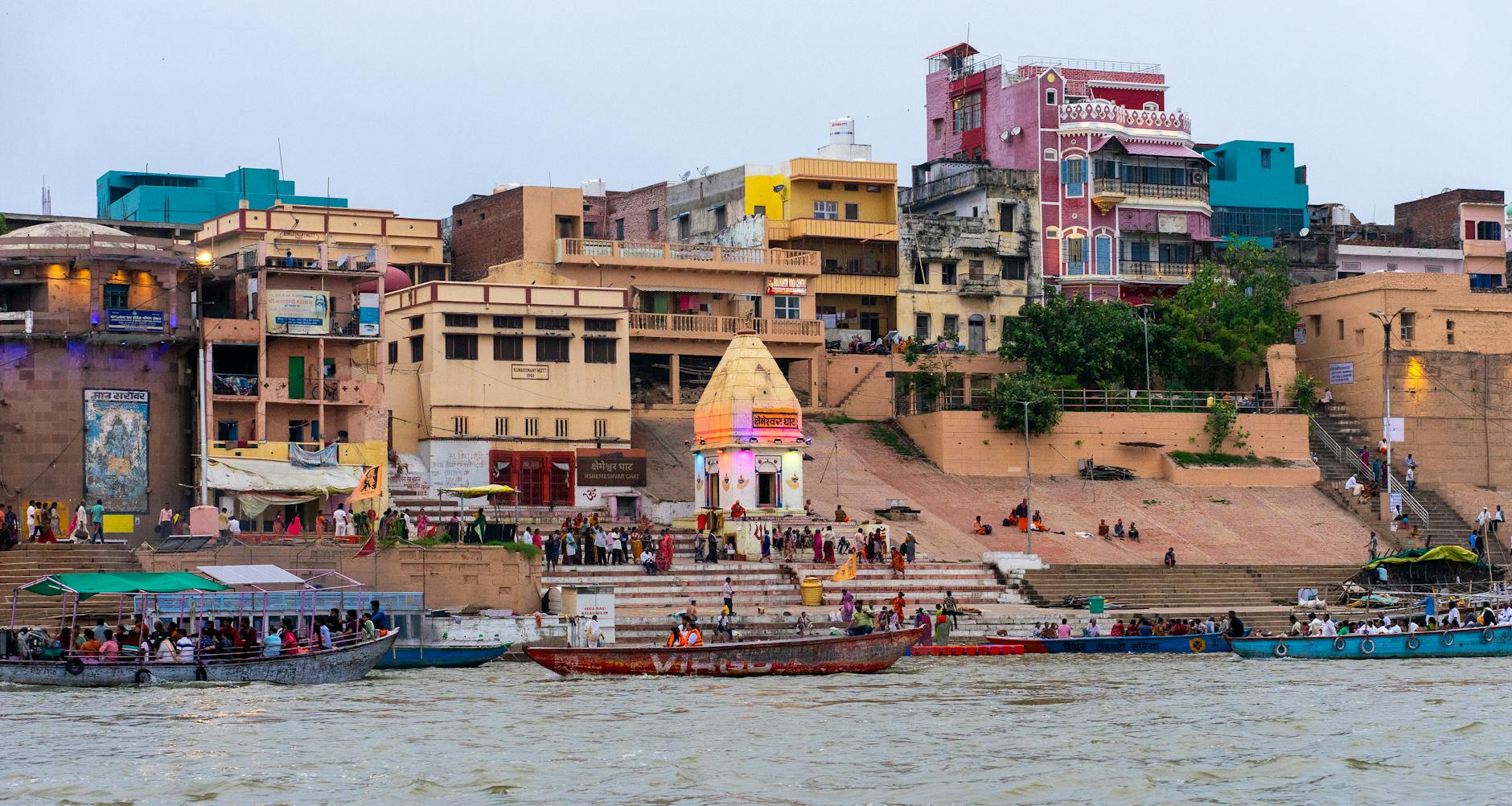 Colorful riverside buildings and boats on the Ganges River in Varanasi, India.
