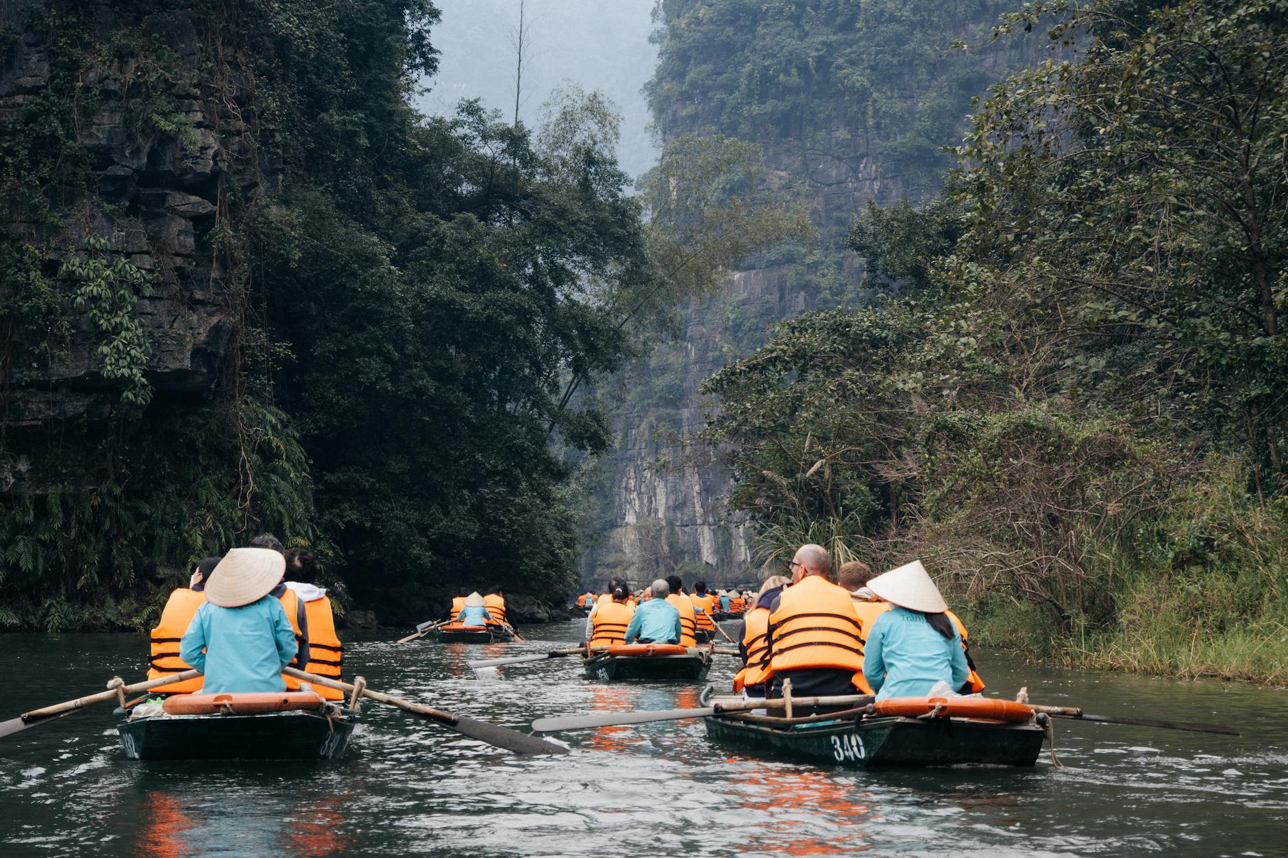 Experience the serene beauty of Ninh Binh, Vietnam with a peaceful boat tour through lush landscapes.