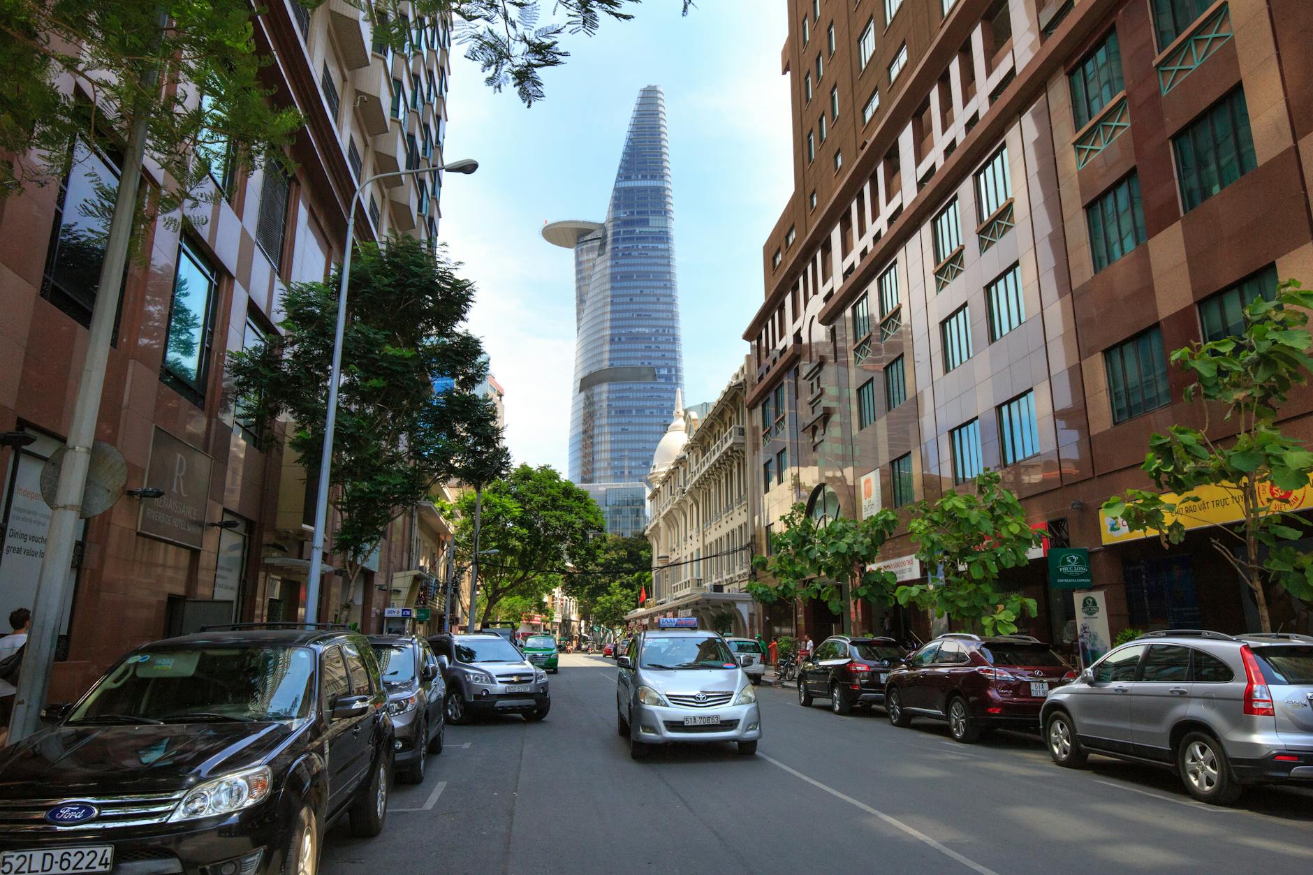 Dynamic street view of Ho Chi Minh City with Bitexco Financial Tower in background.
